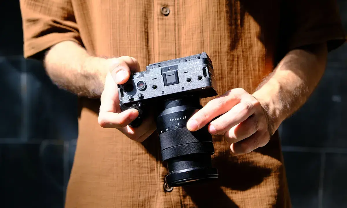 Dłonie trzymają aparat Sony FX3 z obiektywem FE 4/24-70.