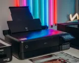 Nowoczesne urządzenie do robienia odbitek Epson, gotowe do drukowania zdjęć w żywych kolorach, otoczone neonowym światłem.